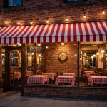 Primanti Bros locations near me: restaurant storefront glowing at dusk